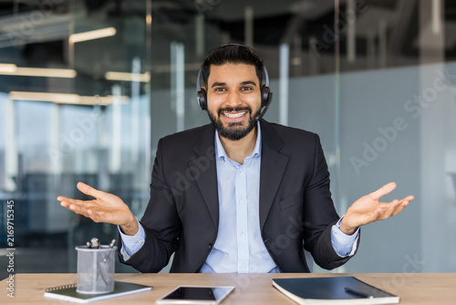 Принти на полотні Smiling male customer support agent wearing headset in modern office, offering f