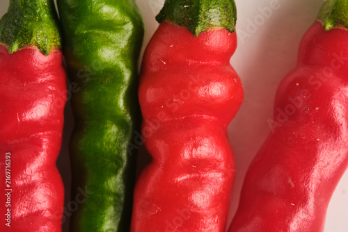 Extreme macro close up showing the vivid skin texture red and green spicy hot chili peppers.