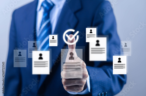 Fotografie Businessman selecting a qualified candidate with a digital checkmark surrounded by resumes, symbolizing recruitment hiring talent acquisition, human resources employee selection, staffing, and career