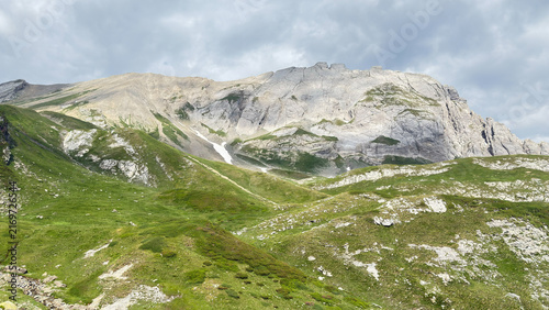 Photography Alpine mountain peak green slopes rocky ridge cloudy sky high altitude rocky ter
