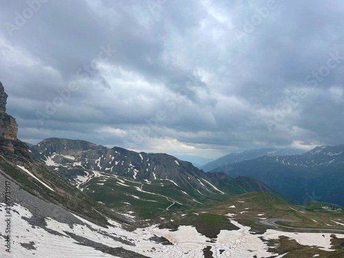 Photography Alpine mountain range snow patches overcast sky dramatic clouds high altitude ro