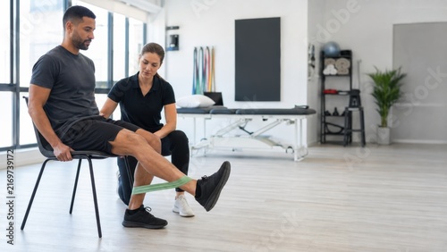 Man Performing Knee Extension Exercise with Physical Therapist