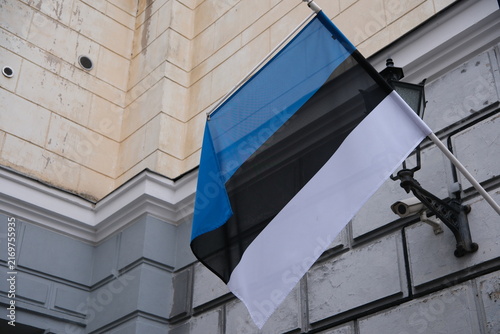 Estonian national flag hanging on a building wall