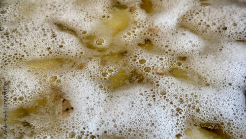 Obraz na plátně White foam boiling on the water surface in a pot close-up