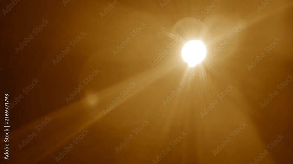 Naklejka premium abstract photo of light burst among trees and glitter bokeh. image is blurred. yellow golden bokeh pattern background. Real optical lens flare on black backdrop. sunrays, sun rays beam, burst, sunbeam