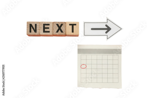 Wooden Blocks with the Word NEXT and a Calendar
