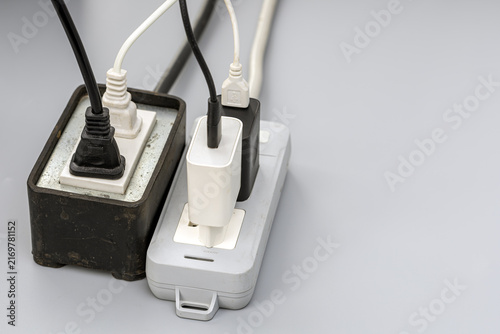 Принти на полотні Close-up of two old, dirty power strips overloaded with multiple tangled black a