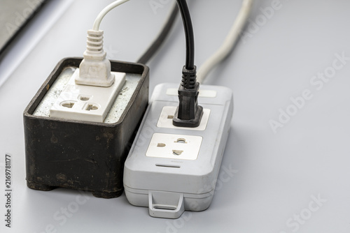 Картината върху платно Close-up view of two old, dusty power strips with white and black electrical cor