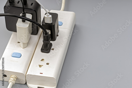 Obraz na płótnie Close-up view of a white electrical extension power strip overloaded with severa