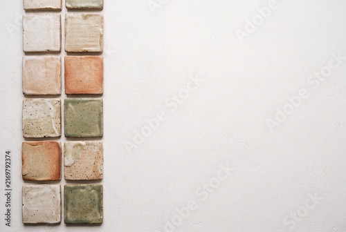 Handmade ceramic tiles arranged beside clean copy space