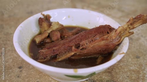 Traditional Malaysian Bak Kut Teh featuring tender pork ribs and meat simmered in a dark, aromatic herbal broth, served in a white bowl.