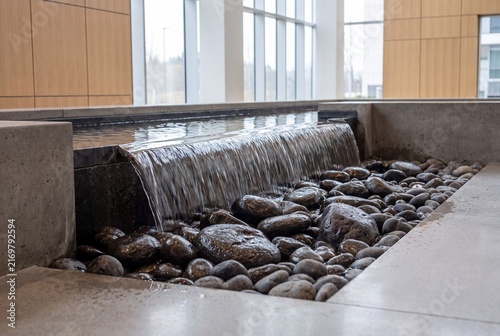 Indoor water feature flowing over dark basalt stones