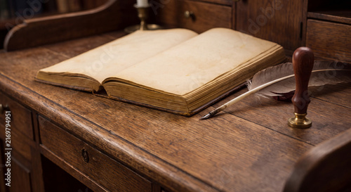 Antique open journal with blank parchment pages resting beside a feather writing quill and wax seal on a wooden desk in study