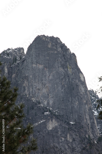 Massive Granite Rock Cliff Towering Above Pine Trees in Yosemite Valley