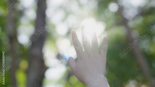  The young woman is pulling her hand toward the sunlight.