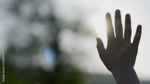  The young woman is pulling her hand toward the sunlight.