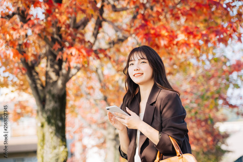 紅葉の季節にお出かけをする女性