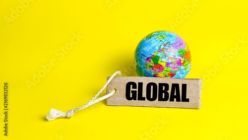 Small world globe placed next to a global text tag.