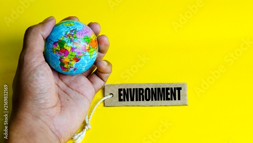 Hand holding world globe next to environment tag.