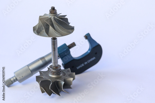 Obraz na płótnie Standing turbocharger turbine compressor shaft assembly with precision outside micrometer gauge on white background