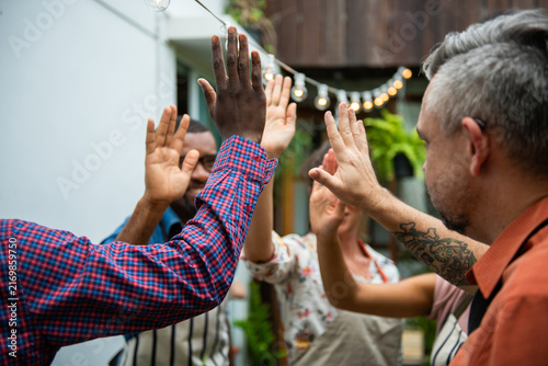 фотографія Diverse group of people high-fiving outdoors in a celebratory gesture