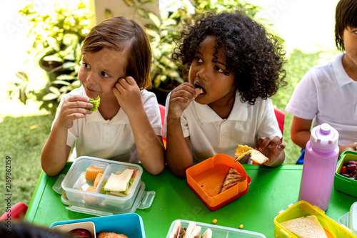 Children enjoying healthy lunch outdoors.