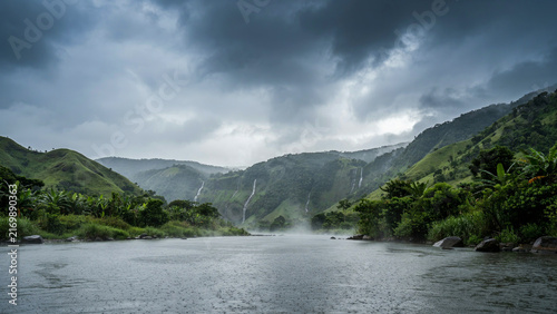 Dramatic mountain landscape with a winding river cutting through lush green