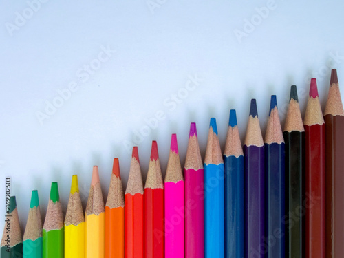 Colorful colored pencils arranged in ascending order on white background with copy space