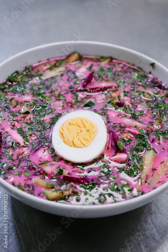 Принти на полотні Chilled pink beet soup in a white bowl topped with a halved hard-boiled egg and fresh chopped herbs
