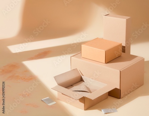 Kraft cardboard shipping boxes stacked on warm studio stage