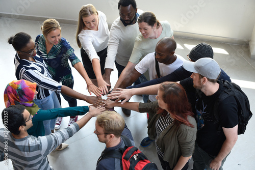 Bild auf Leinwand Diverse group of people standing in a circle, joining hands in unity