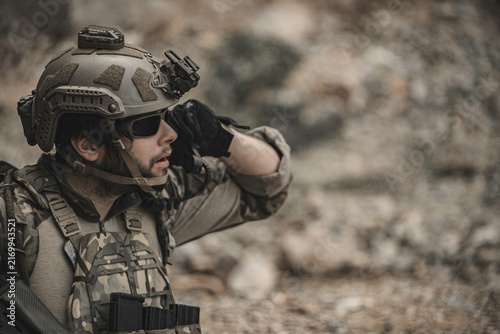 Military soldier communicating during a tactical field operation, demonstrating mission coordination, battlefield communication, situational awareness, leadership, security operations