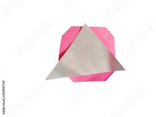 A small pink square paper folded with a shiny silver triangle shape on top