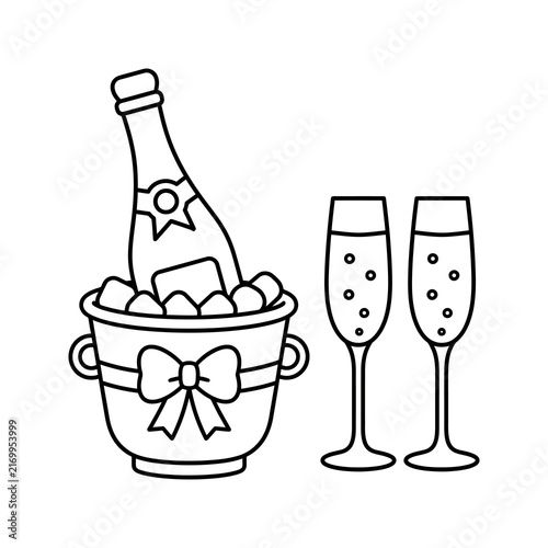 Champagne bottle in bucket with ribbon and two glasses for celebrations.