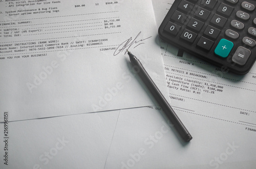 Close up business finance scene featuring signed invoice calculator pen office documents Concept accounting billing payment processing financial management business expenses corporate administration