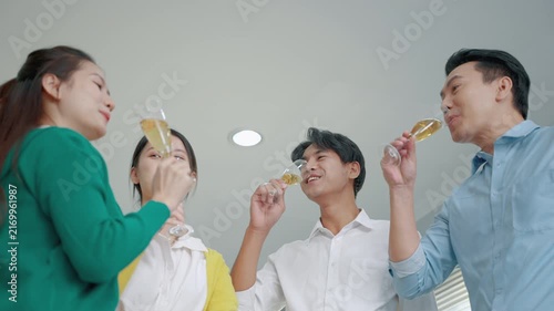Happy colleagues celebrating a business achievement by raising champagne glasses together in an office. The image conveys teamwork, success, employee engagement, company culture and shared accomplishm