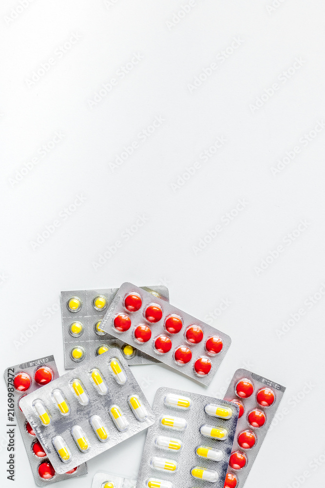 Naklejka premium doctor's work desk in hospital with pills white background top view mockup