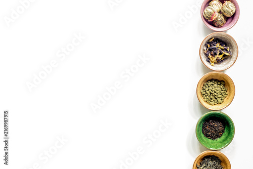 Canvas Print herbs in colorful bowls to make tea on white table background top view mock-up