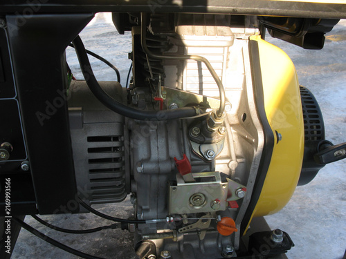 Generator placed on the ground with snow in the background during winter daylight