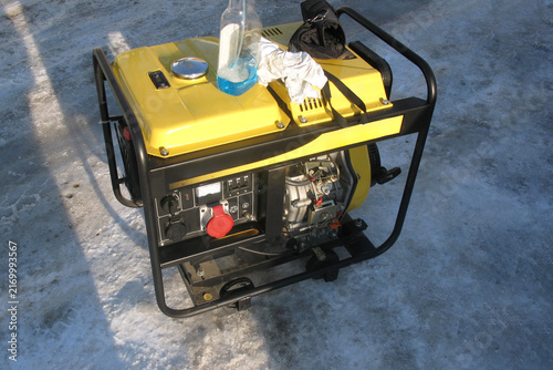 Generator placed on the ground with snow in the background during winter daylight