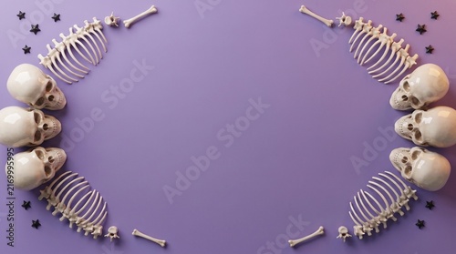 Halloween skull and rib cage border frame on a purple background with copy space