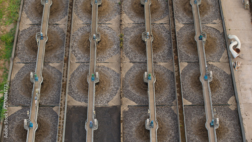Aerial view of the wastewater treatment plant featuring large aeration tanks with mechanical agitators and industrial infrastructure in Wanlip, England, United Kingdom.