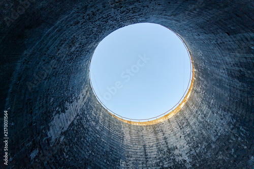 Konstfotografi Industrial tower from the inside with circular opening and blue sky