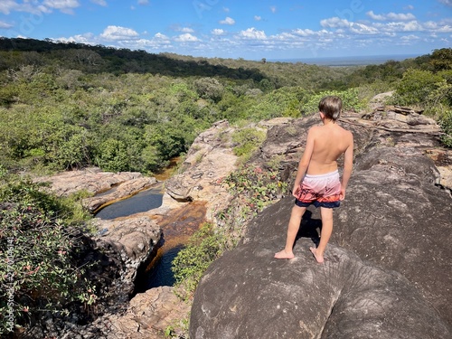 Boy looking down at Las Pozas, natural crystal-clear pools in the Chiquitania region of Bolivia.