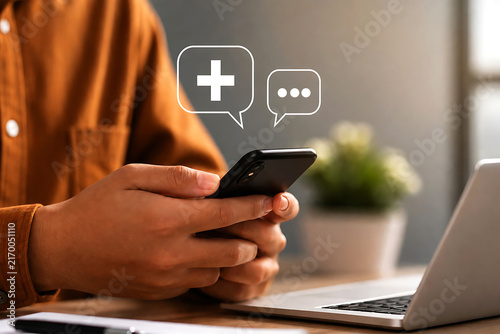 Person holding a smartphone with floating speech bubble featuring a plus sign and dots, suggesting medical or communication services