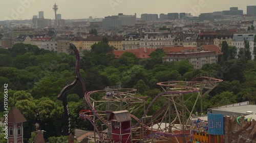 Vienna, Austria amusement park with roller coaster rides overlooking the city skyline, featuring historic architecture and urban landscape.