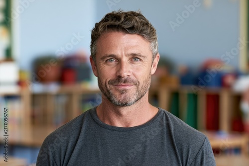 Middle-aged man with beard smiling in colorful classroom background