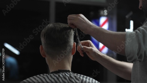 Fotografie Skilled barber trimming client's hair with precision scissors, working inside vi