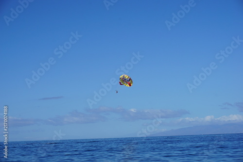 Foto Parasail gliding above ocean under clear blue sky
