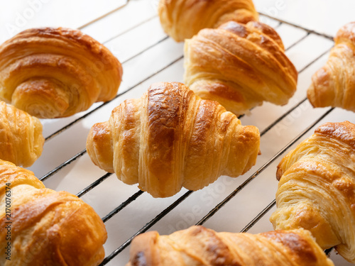 Freshly baked golden color of traditional French croissantscooling on a wire rack homemade artisan viennoiserie pastry.